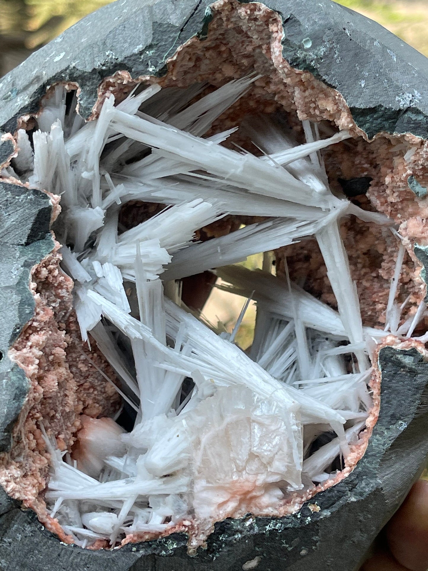 Scolecite spray inside orange heulandite geode