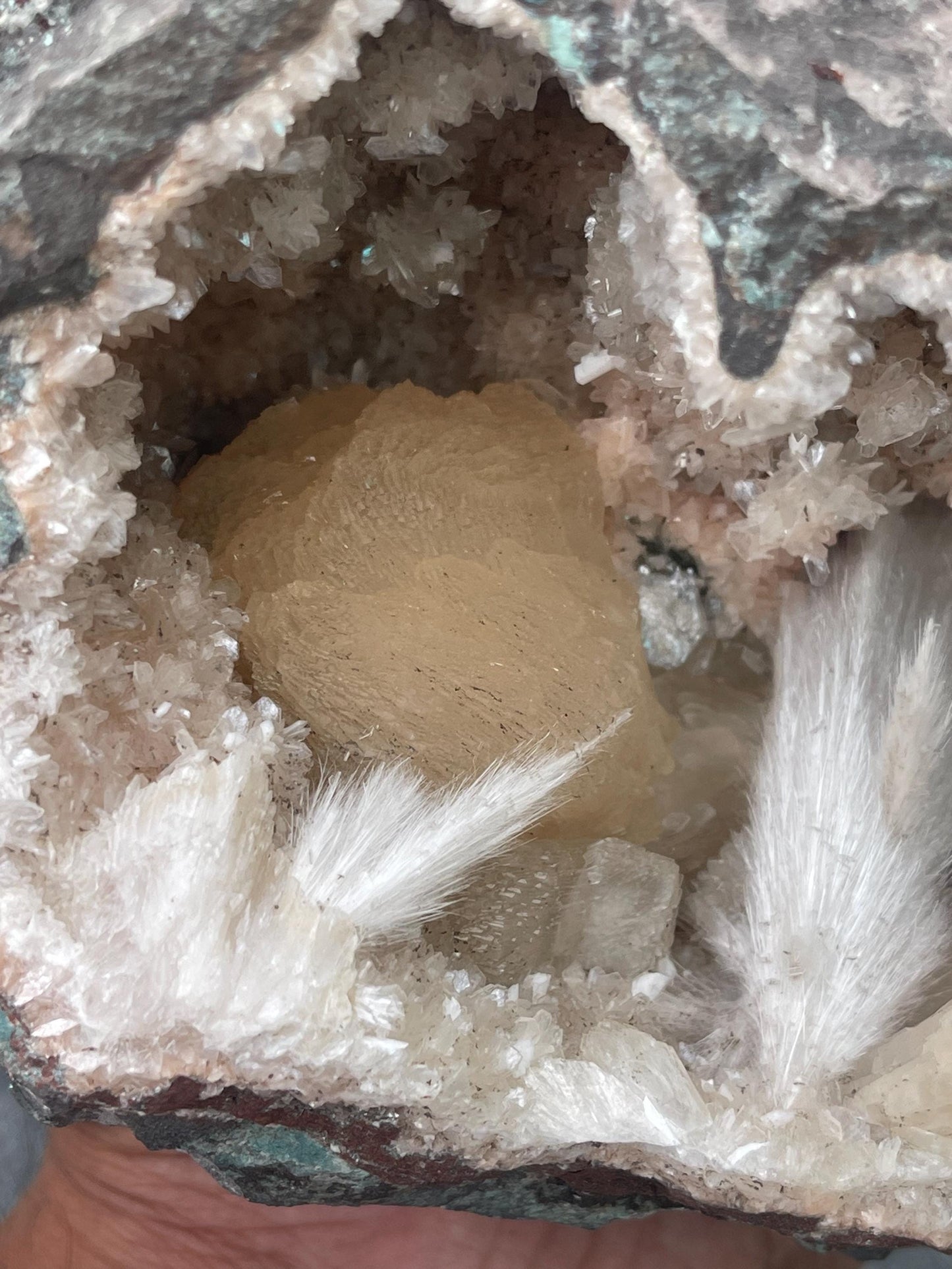 Combination of Scolecite sprays and peach stilbites inside heulandite geode