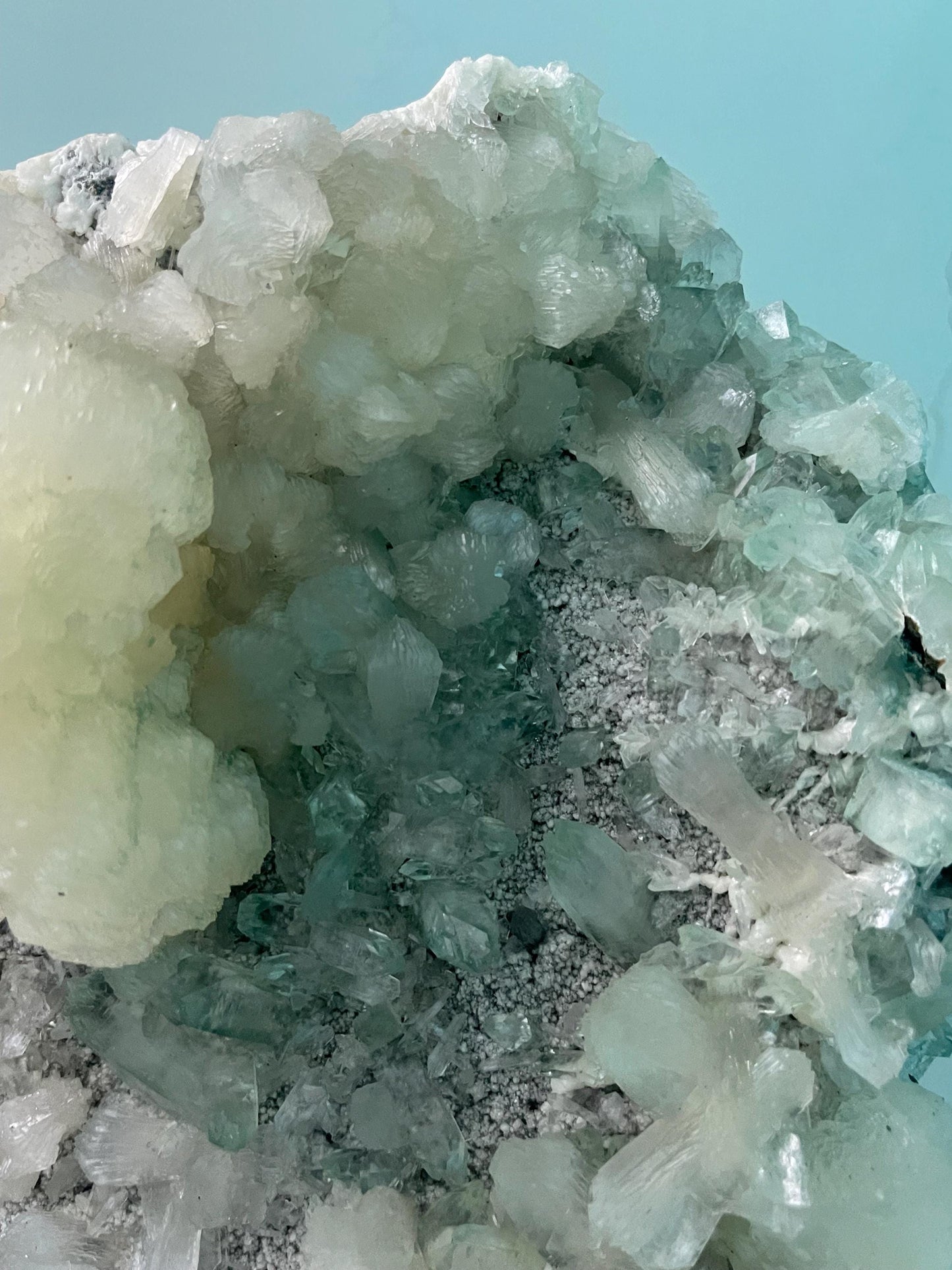 pointed light green apophyllite crystal with stilbite