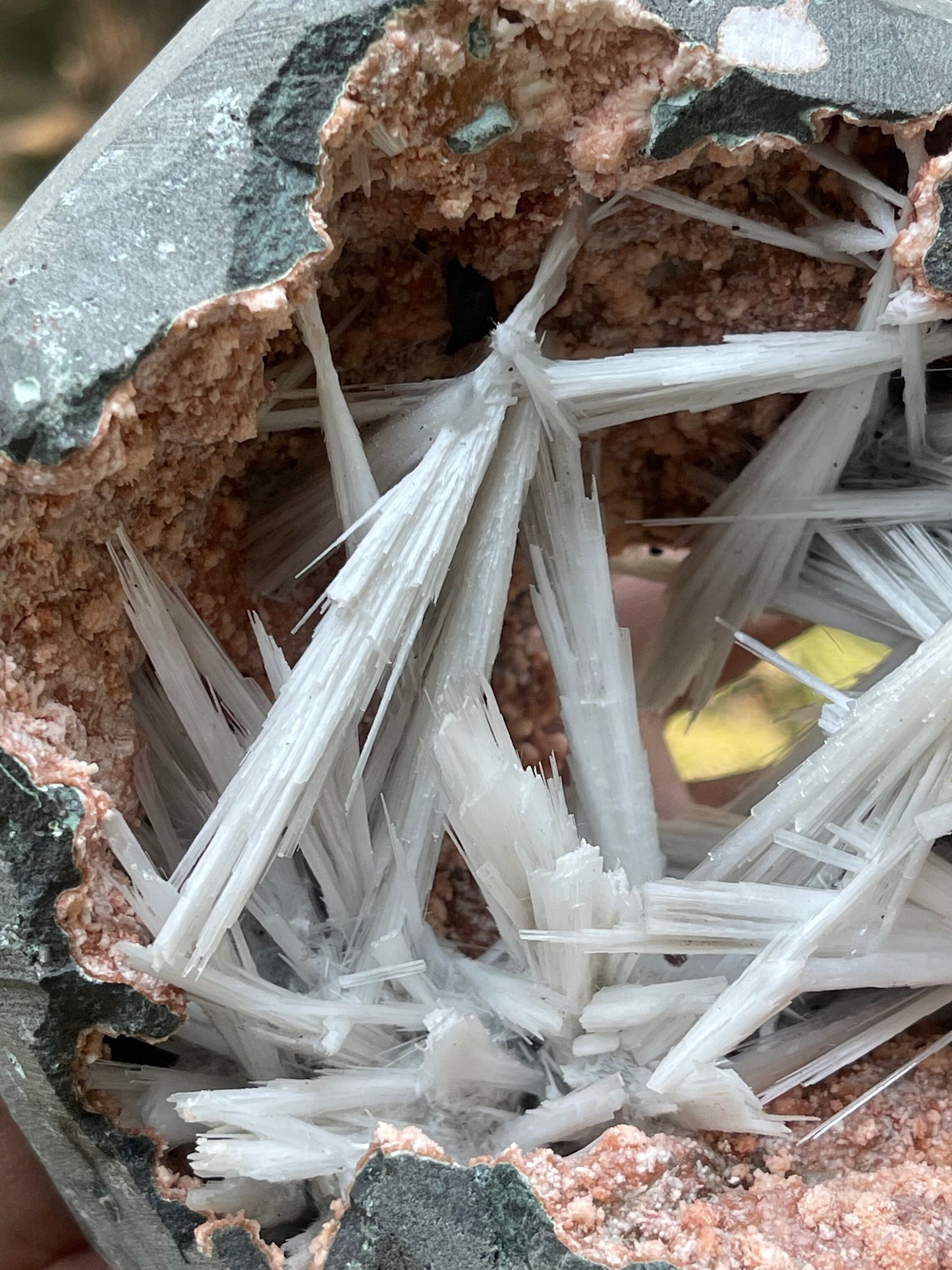 Scolecite spray inside orange heulandite geode
