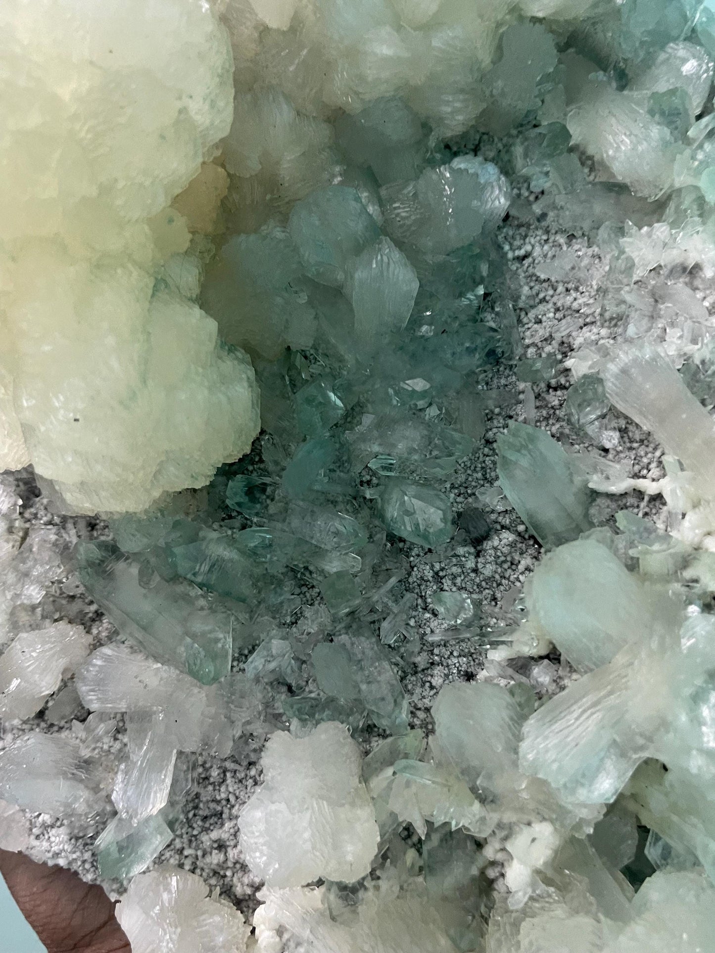 pointed light green apophyllite crystal with stilbite