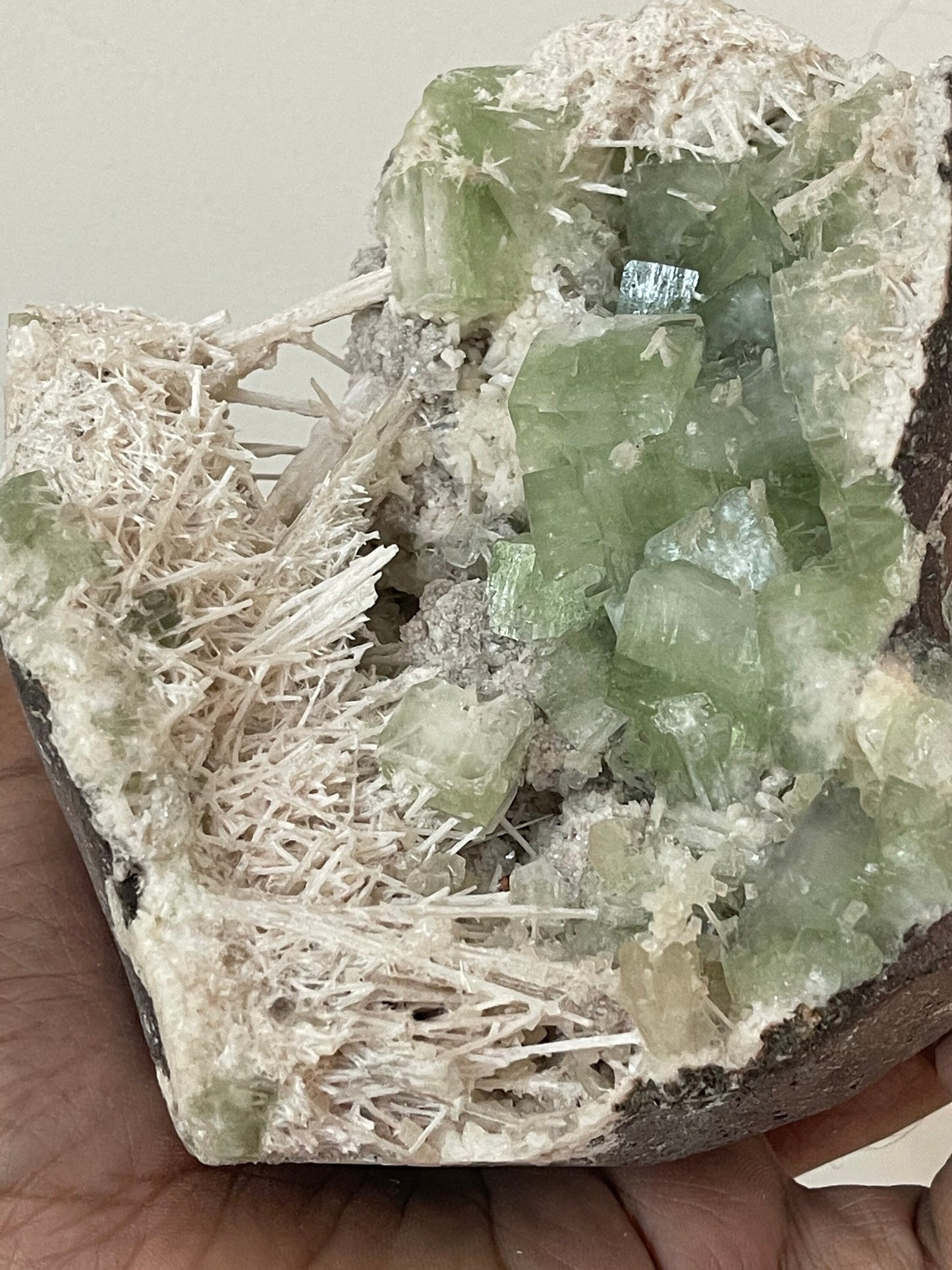 Green apophyllite crystal with scolecite sprays base geode