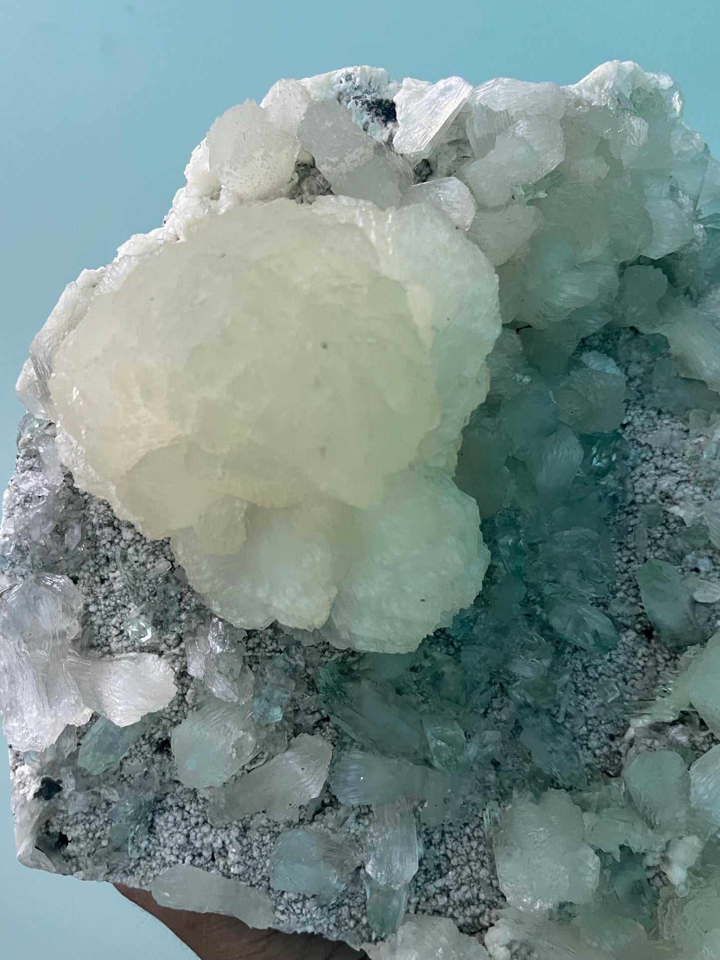 pointed light green apophyllite crystal with stilbite